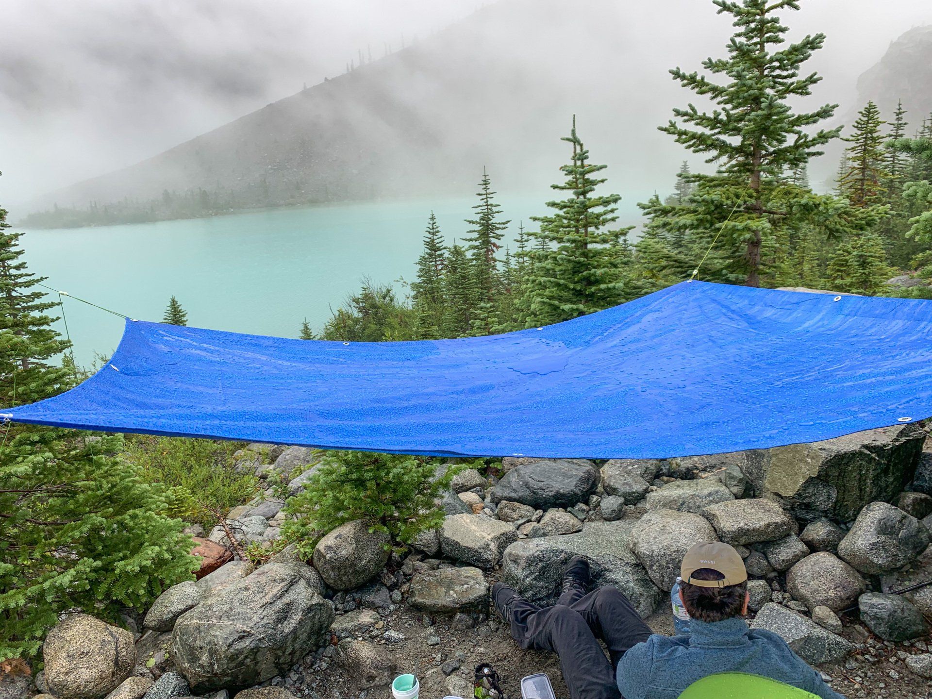 Blue poly tarp hanging over a camp with a view of upper Joffre lake, Joffre Lakes Provincial Park, BC, Canada