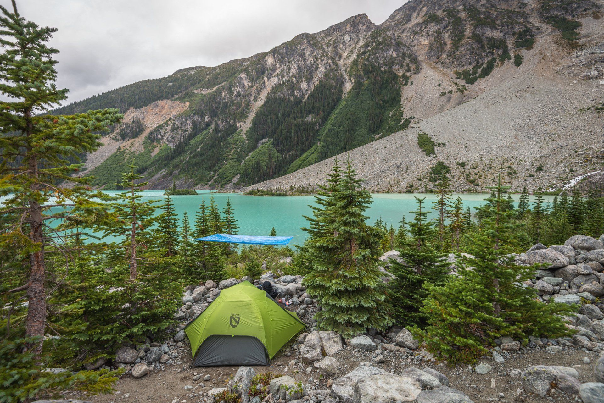 Nemo Dragonfly tent with a blue poly tarp hanging above, with a view of the upper Joffre lake, Joffre Lakes Provincial Park, BC, Canada