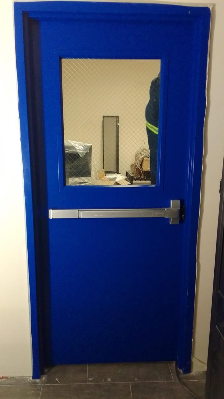 Puerta azul con ventana y barra antivuelco plateada; persona visible en el interior.