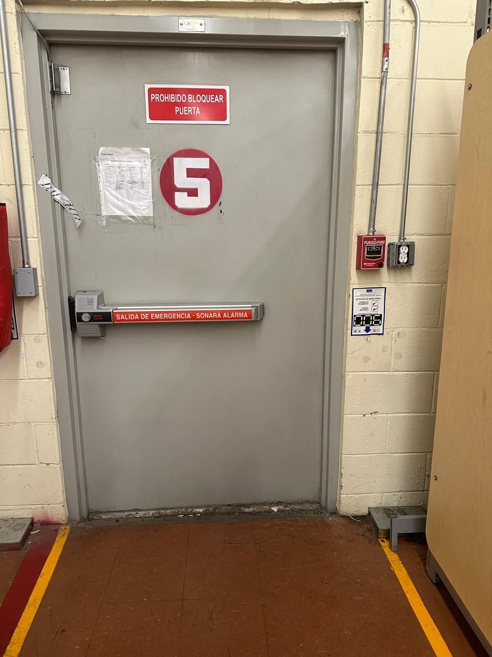 Puerta gris con letrero rojo de 