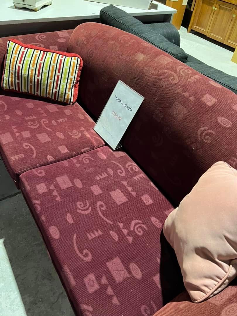 A Red Couch With Pink Pillows and a Sign on It — Anton's New & Used Furniture In Ciccone, NT