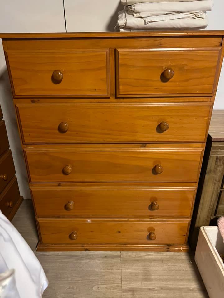 A Wooden Chest of Drawers is Sitting in a Room Next to a Bed — Anton's New & Used Furniture In Ciccone, NT