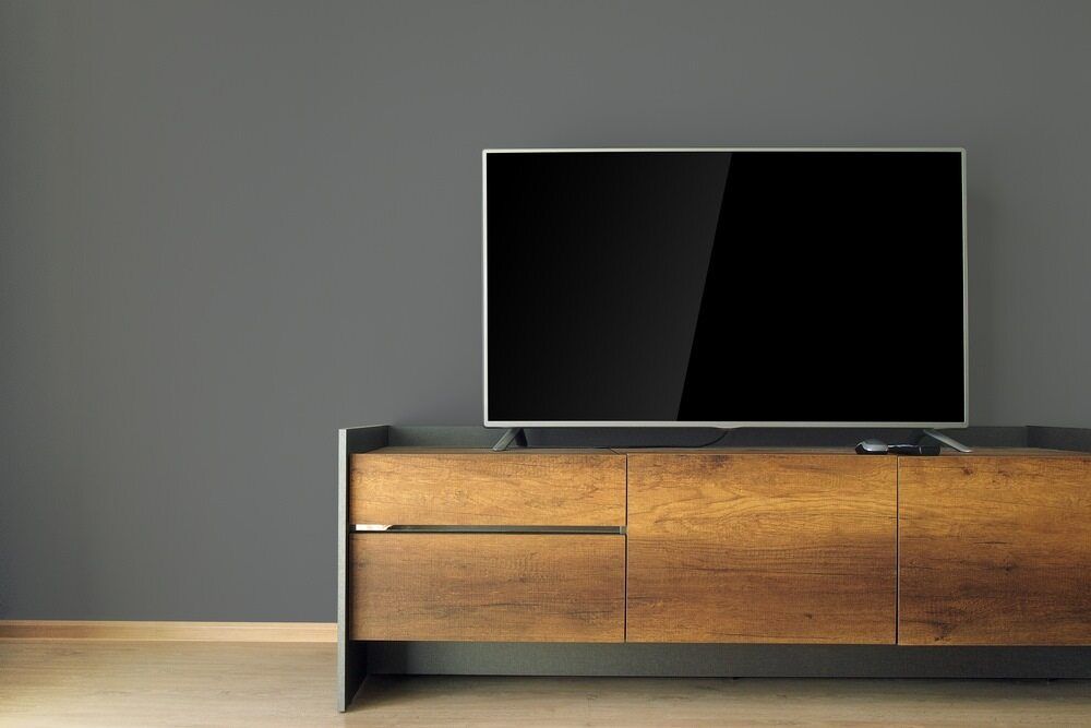 A Flat Screen Tv is Sitting on Top of a Wooden Entertainment Center — Anton's New & Used Furniture In Ciccone, NT