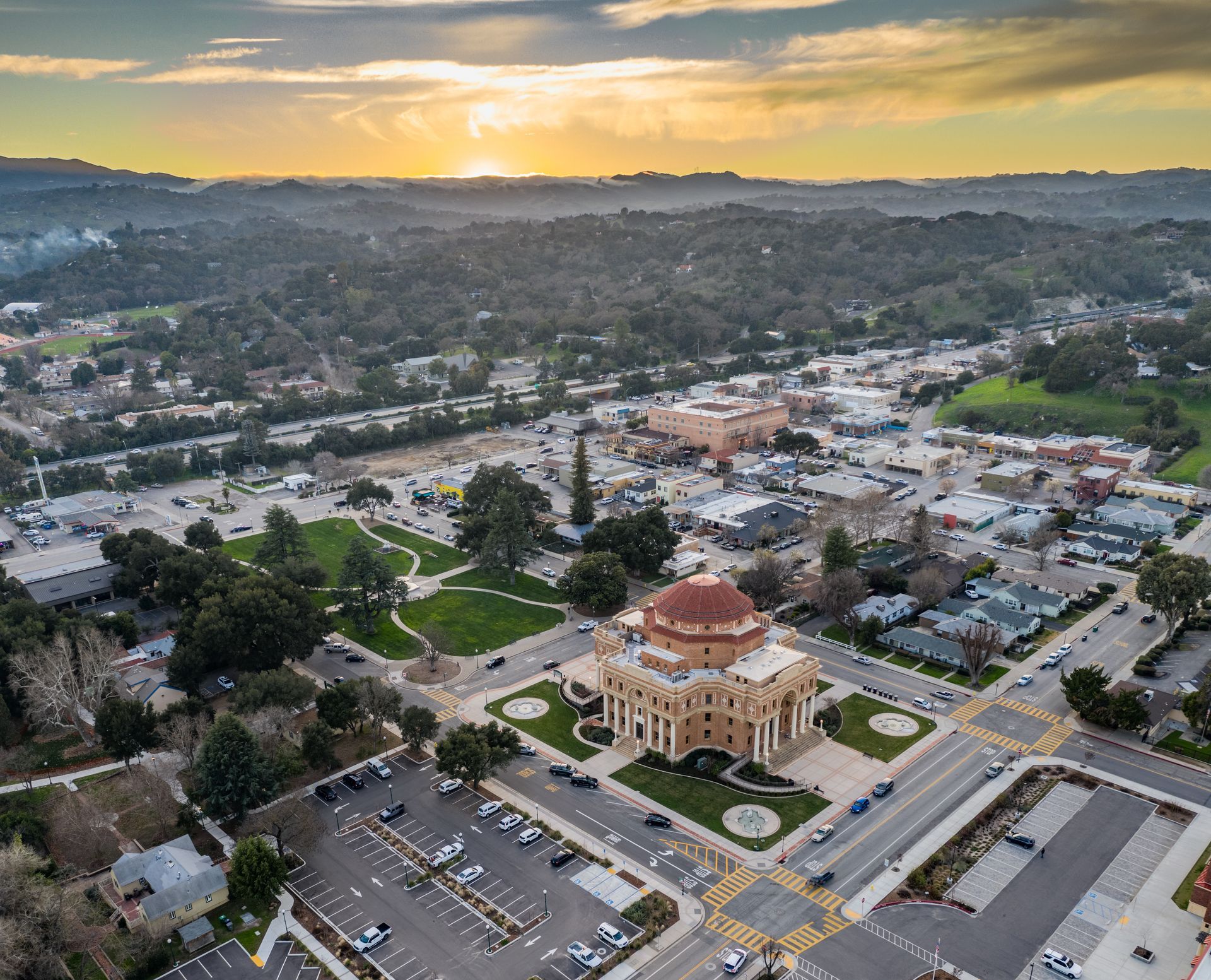 An aerial view of a city with a large building in the middle of it.
