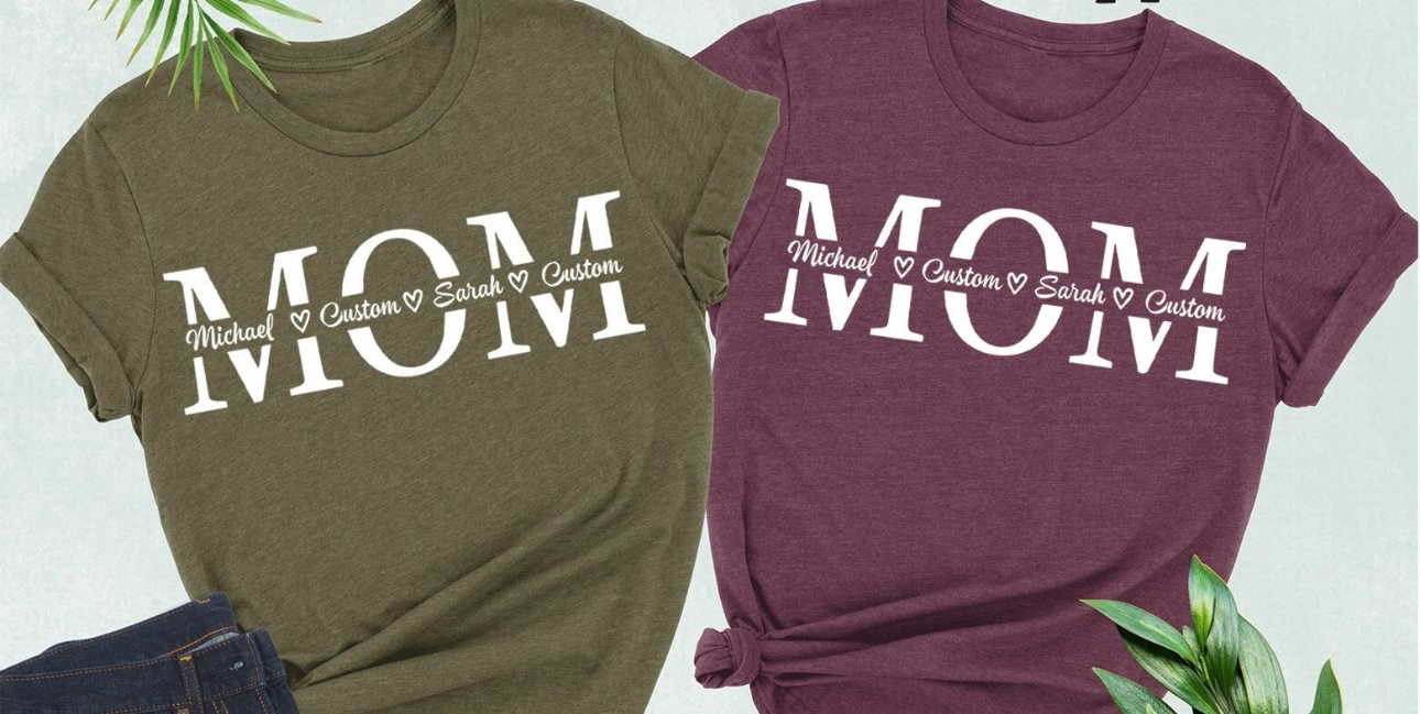 Two t-shirts, one green and one burgundy, with "MOM" printed on them, with names of kids underneath.