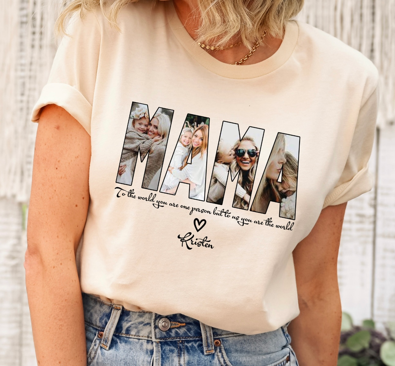 Woman wearing a cream-colored shirt with "MAMA" design, featuring photos. Text below reads "To the world you are a mother, but to our family you are the world" with a heart and signature.