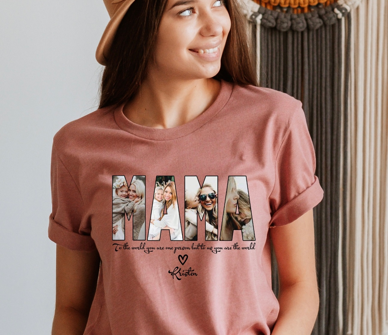 Woman wearing a dusty rose t-shirt with "MAMA" spelled out with photos, smiles.
