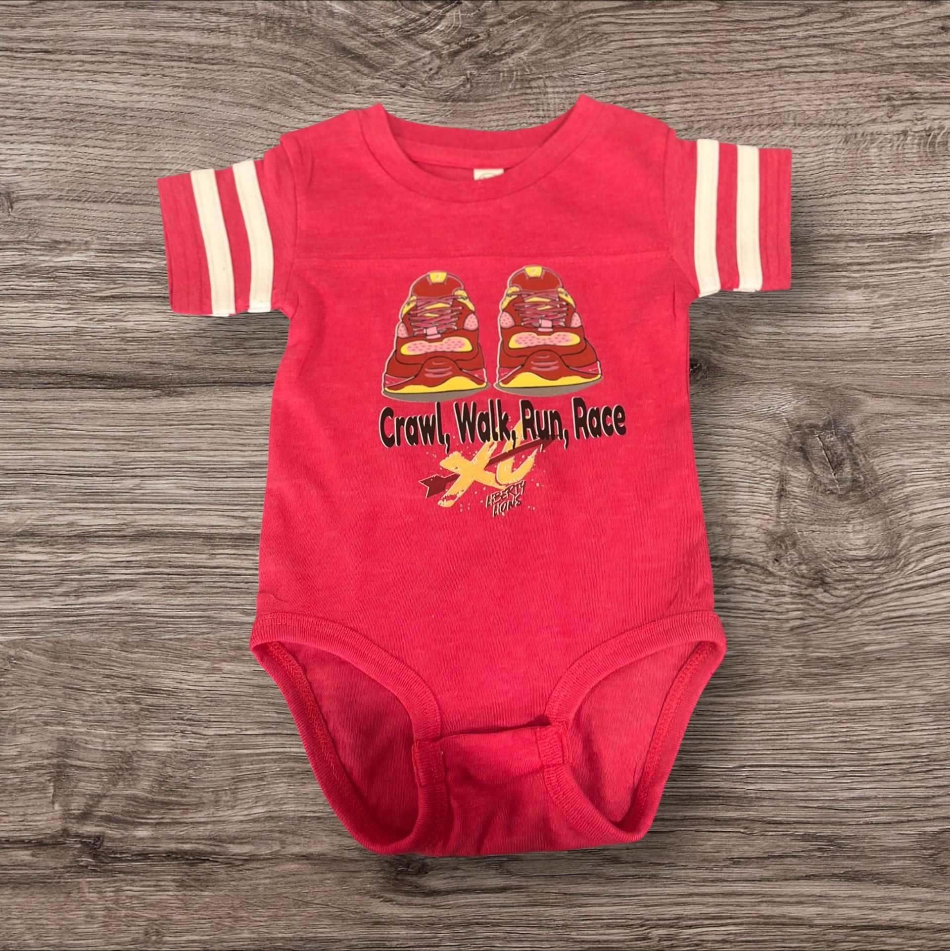 Red baby onesie with football-style stripes on sleeves, print of two babies, and "Crawl, Walk, Run, Race" text.