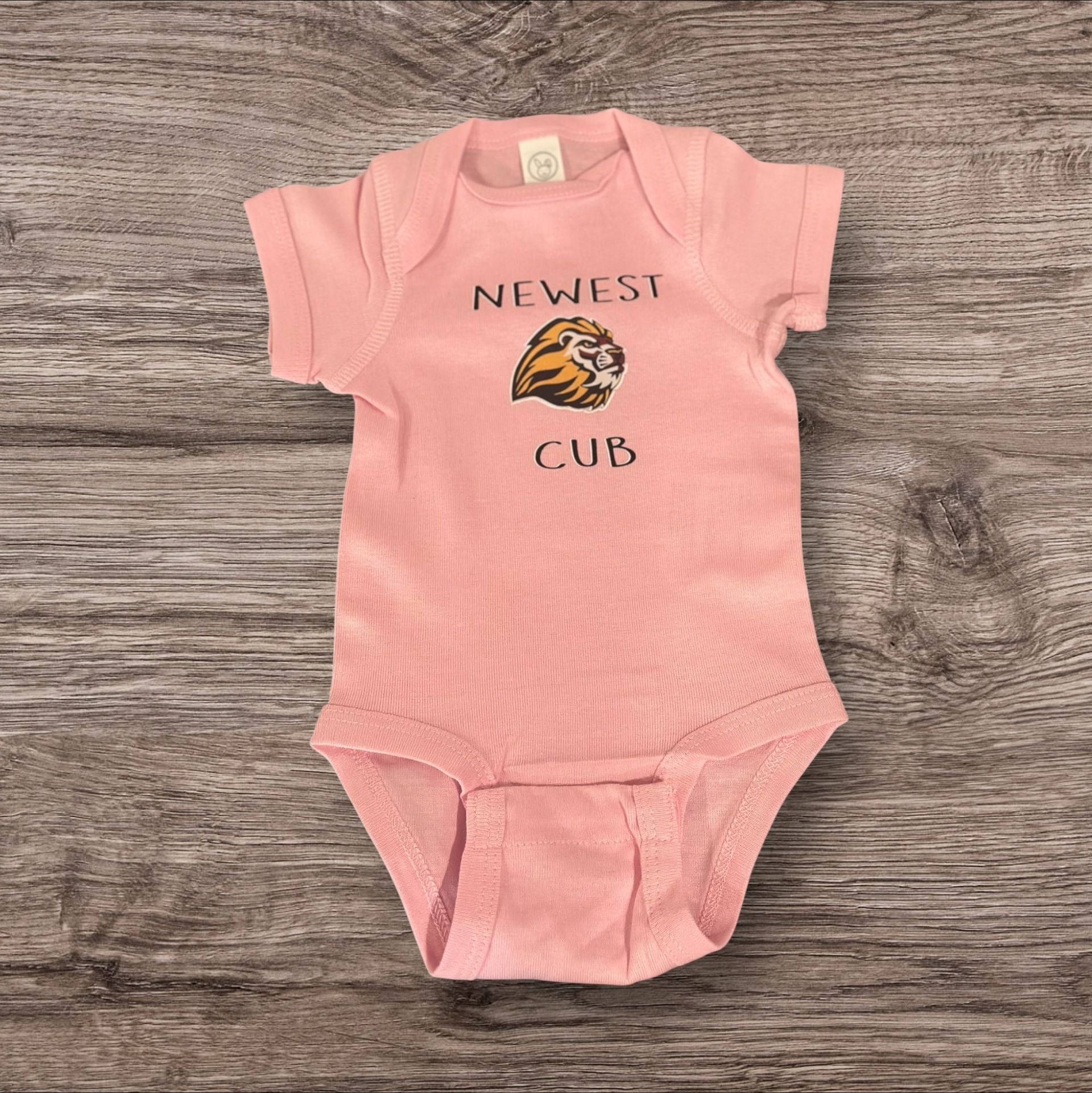 Pink baby onesie with "Newest Cub" text and a tiger graphic.