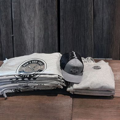 Gray apparel and cap stacked on wooden surface. The gear features a circular logo.