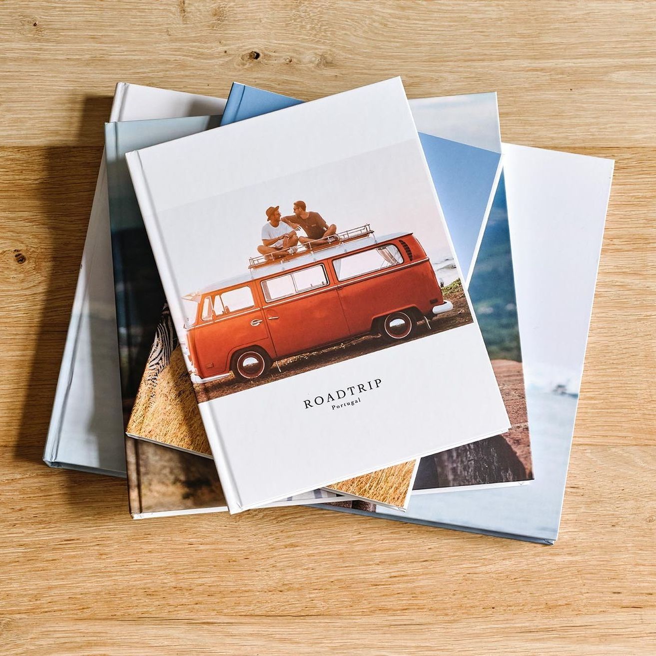 A row of books with pictures on them are sitting on a table.