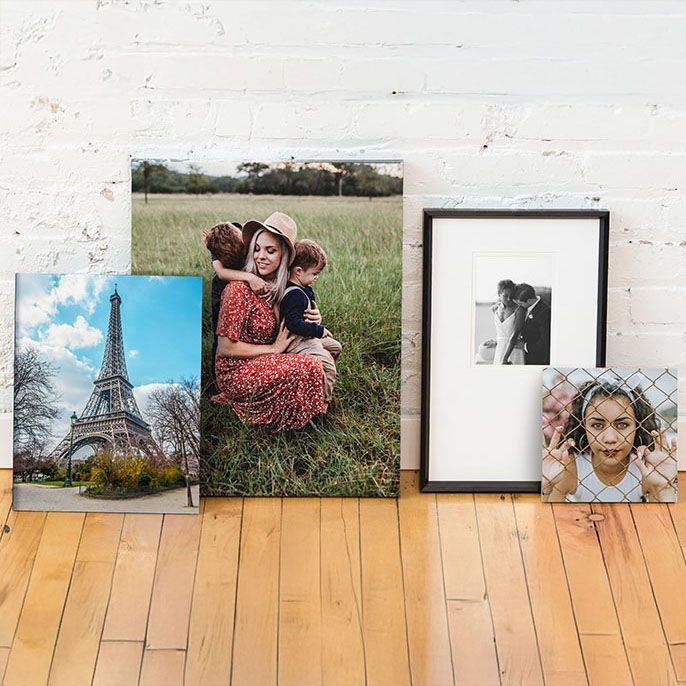 Two paintings are hanging on a wall next to a chair.