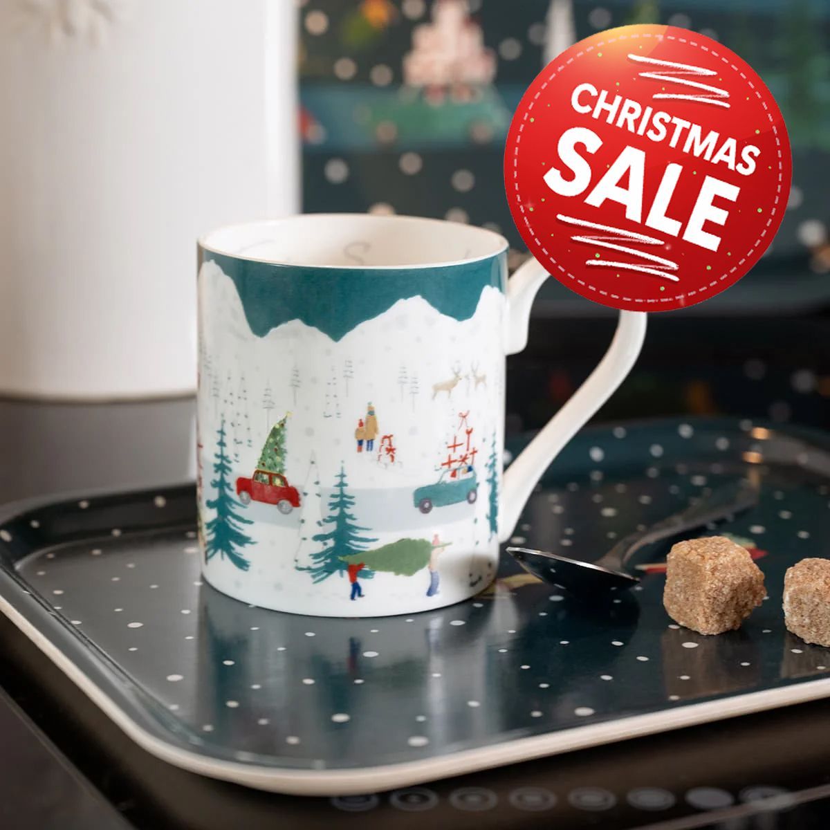 A coffee mug is sitting on a table next to croissants.