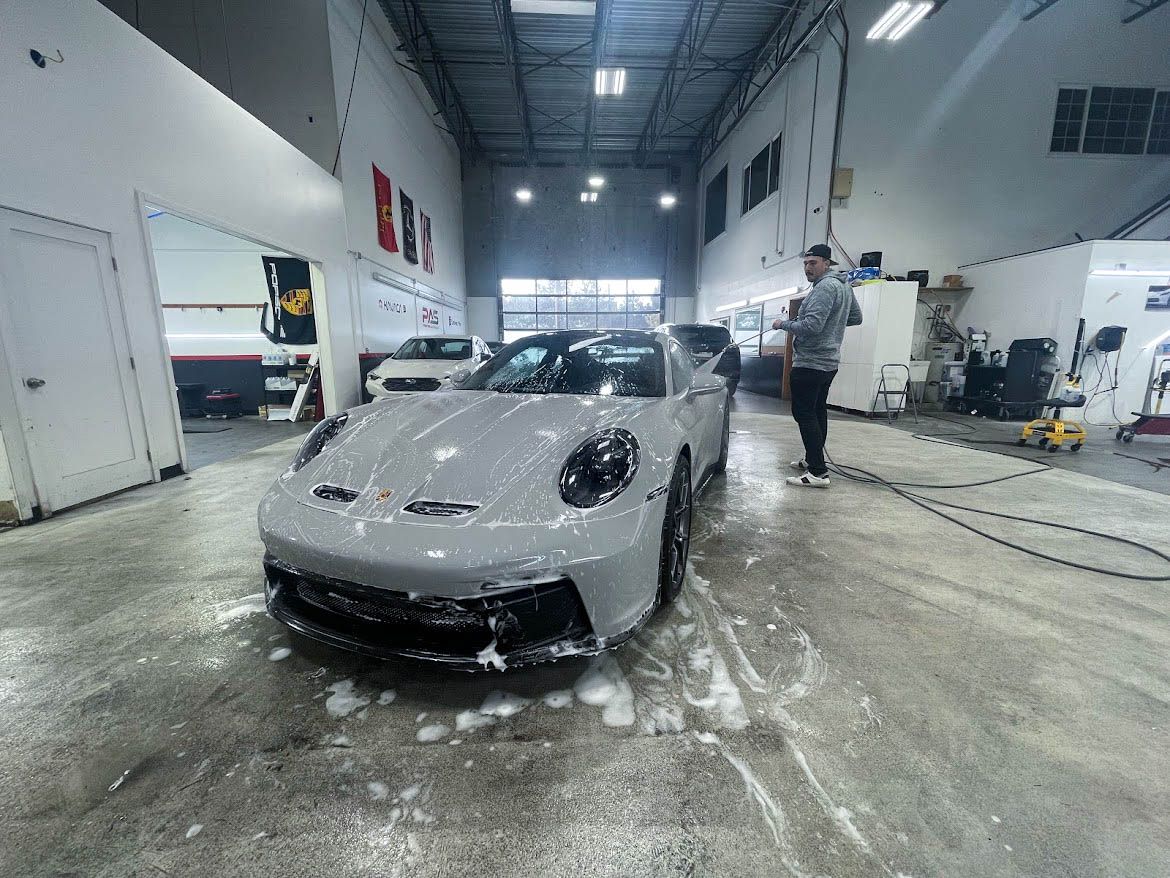 a man is washing a car in a garage .