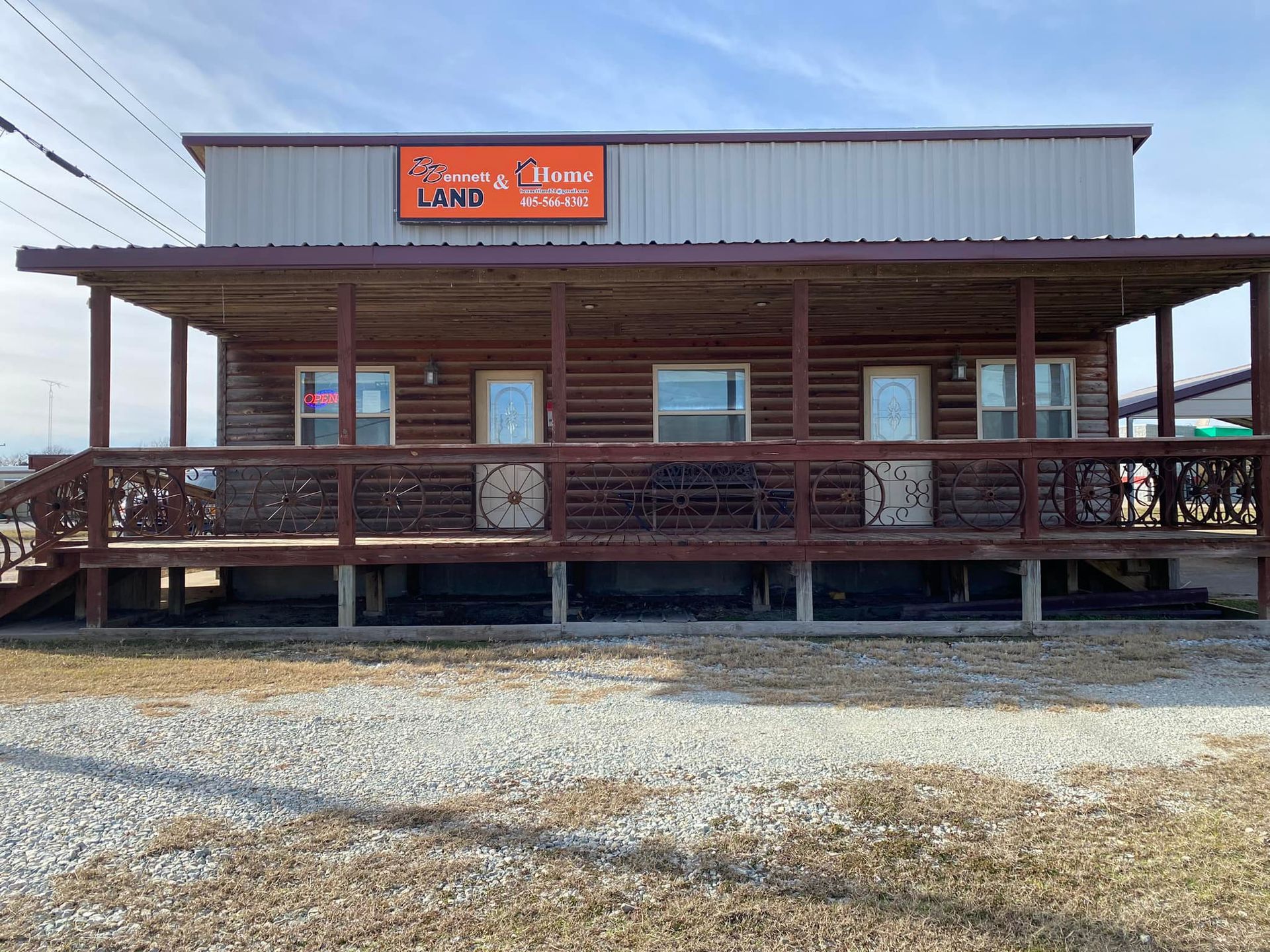 Two-story building with a covered porch. Sign says, 