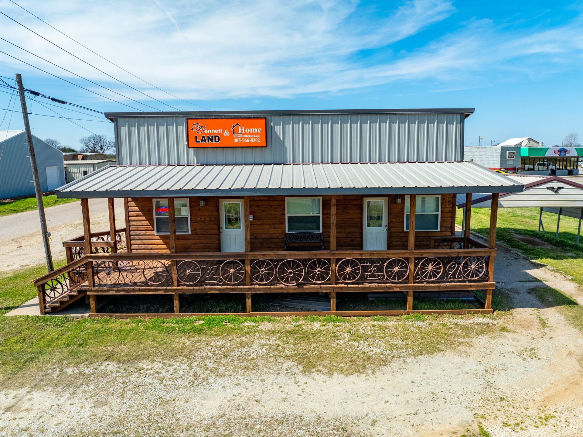 Two-story building with a covered porch. Sign says, 