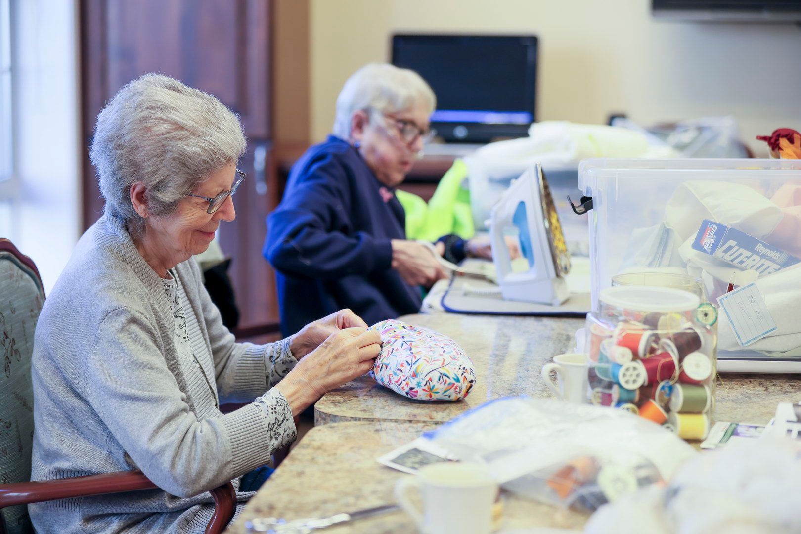 Smiling nurse standing with happy elderly male resident