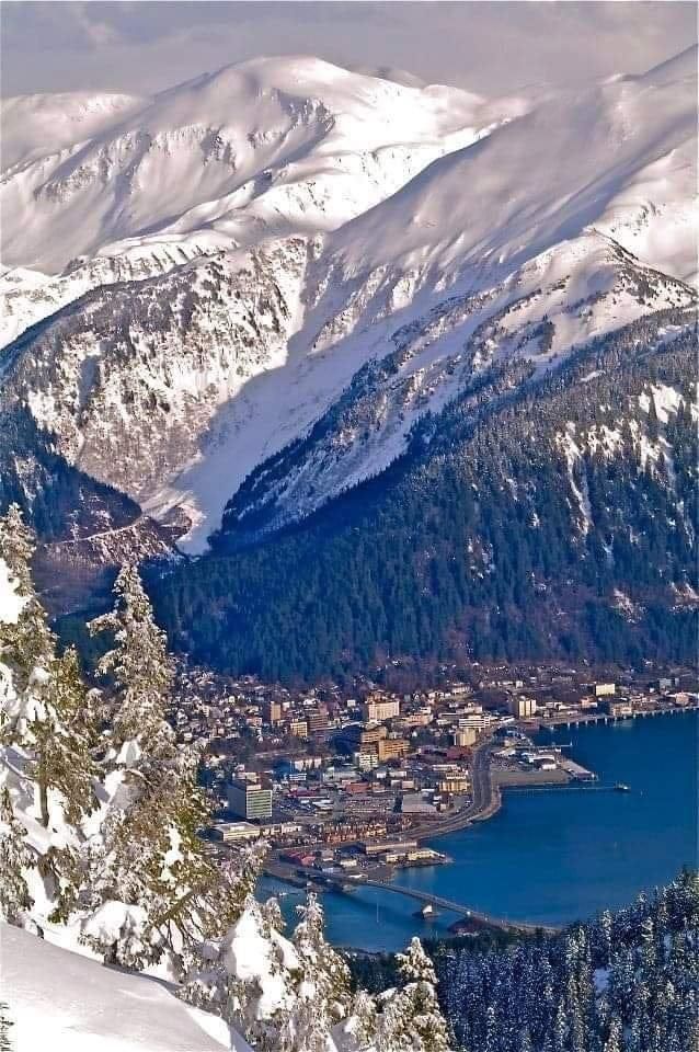 A snowy mountain range with a lake in the middle. Unique Juneau Tours