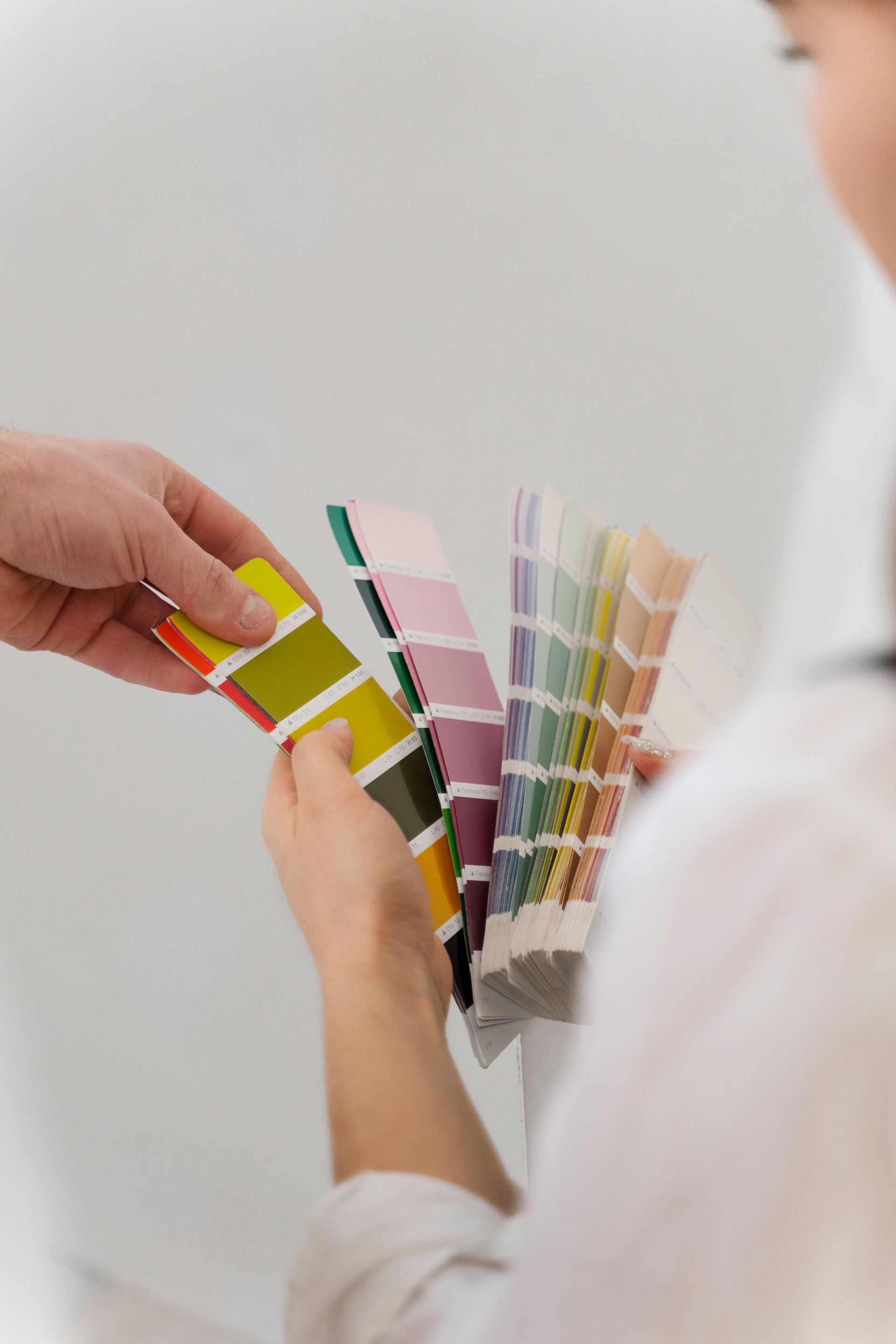 A man and a woman are looking at paint samples.