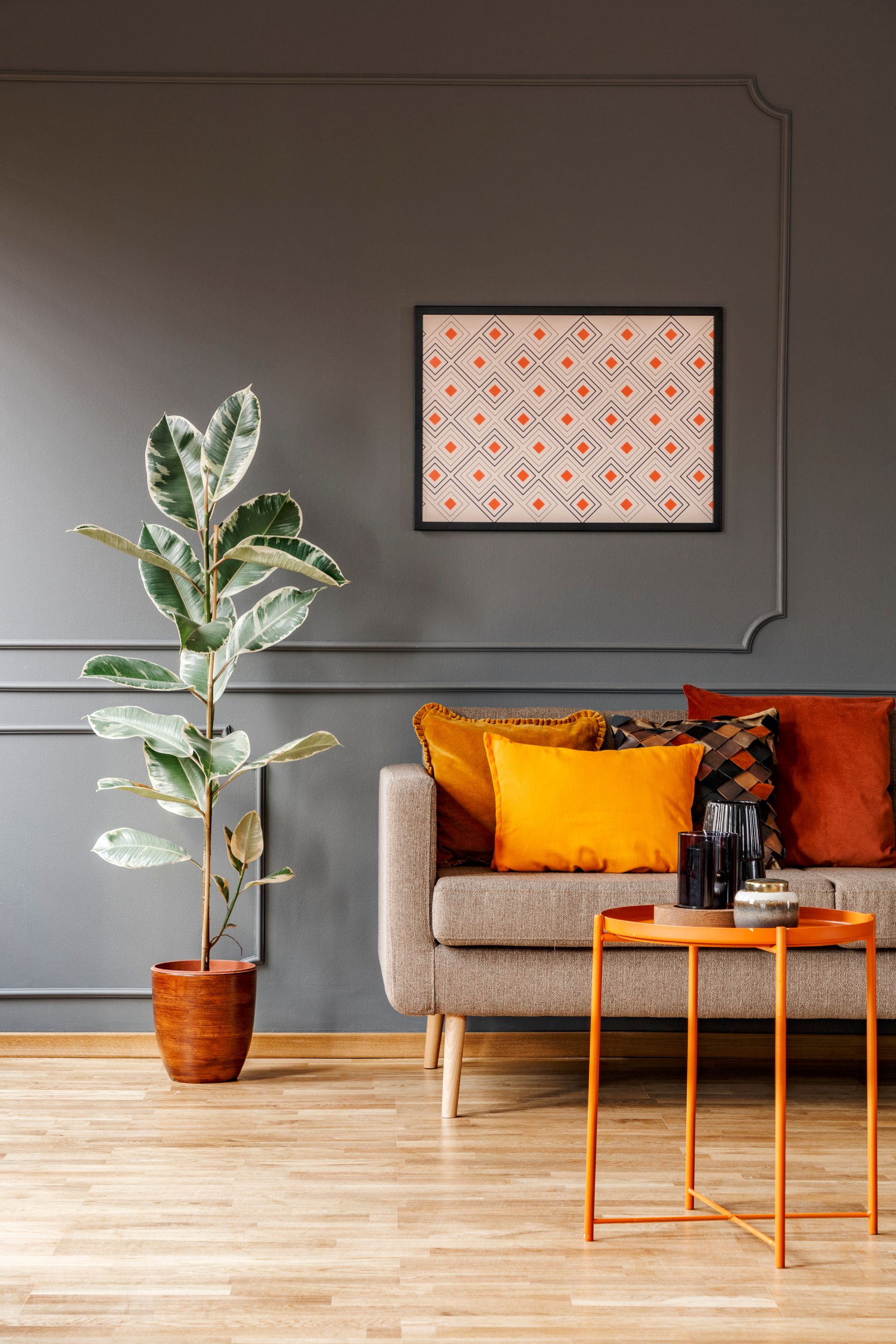 A living room with a couch , table , and potted plant.