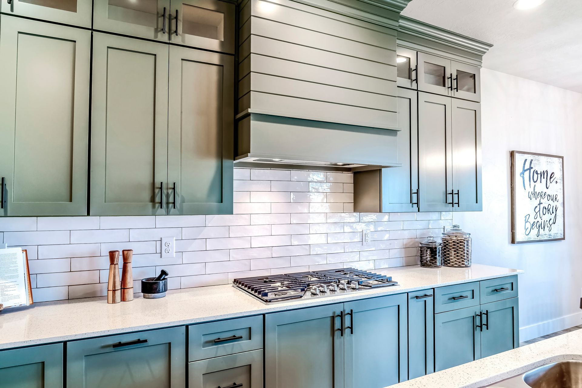 A kitchen with green cabinets and a stove top oven.