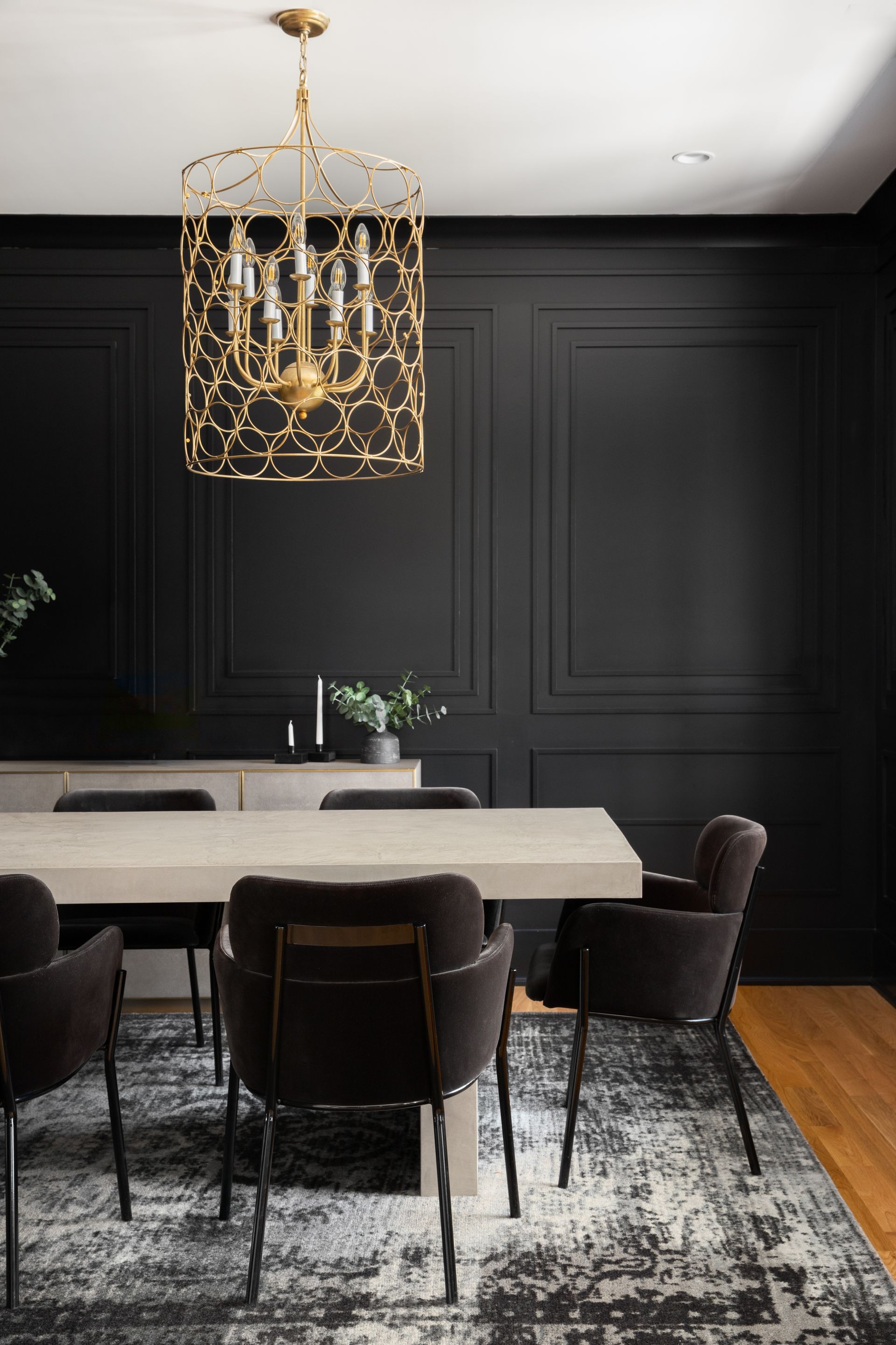 A dining room with a table and chairs and a chandelier hanging from the ceiling.