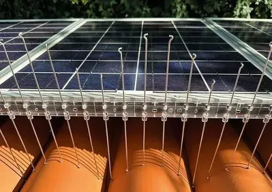 Vista dall'alto di un pannello solare trasparente sopra componenti cilindrici arancioni con cablaggio sottostante