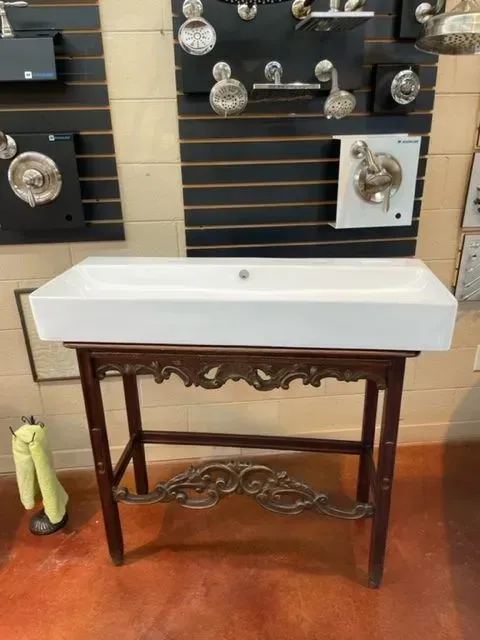 A bathroom sink on a wooden stand in a store
