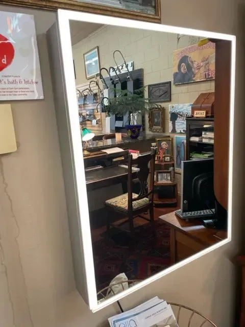 A mirror with a lighted frame in a room