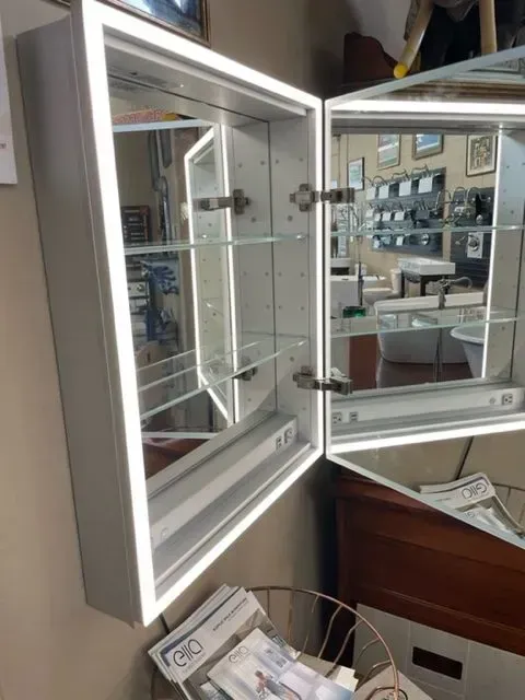 A bathroom mirror cabinet with a light inside of it.