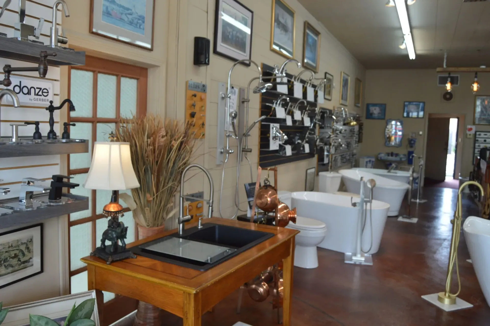 A bathroom showroom with a sink, toilet, and bathtubs