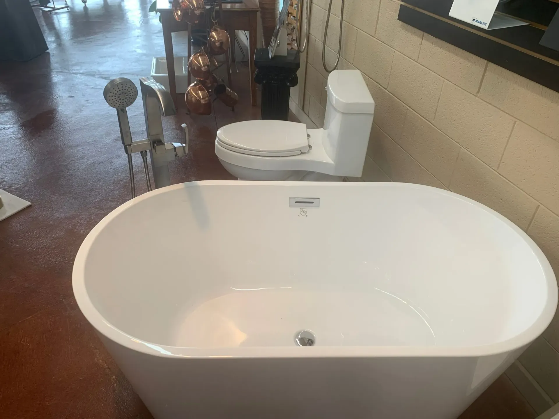 A white bathtub is sitting next to a toilet.
