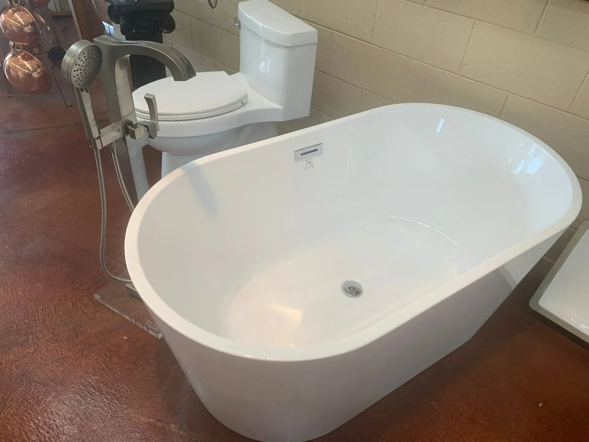 A white bathtub is next to a toilet.