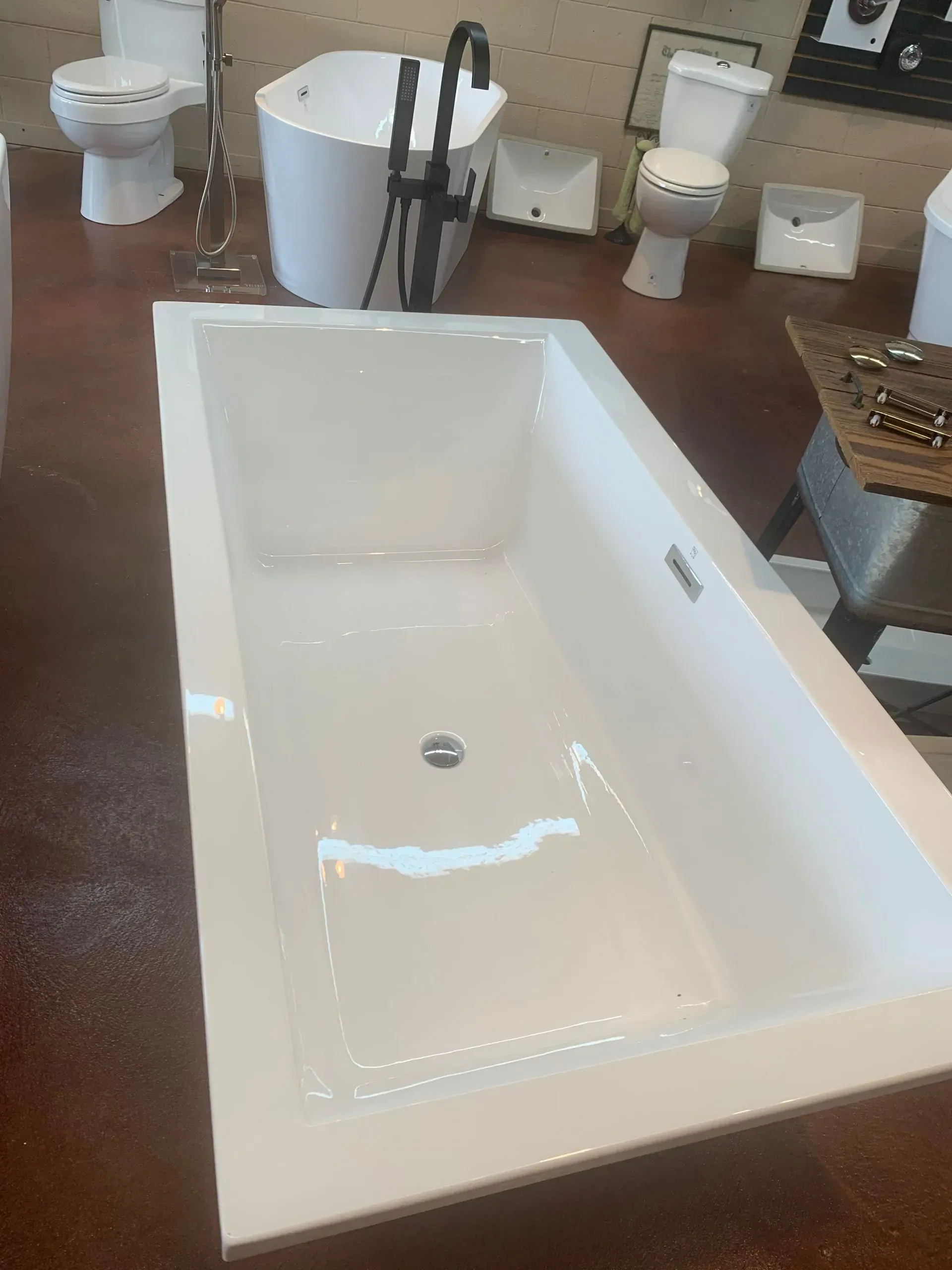 A white bathtub is sitting in a bathroom next to a toilet.