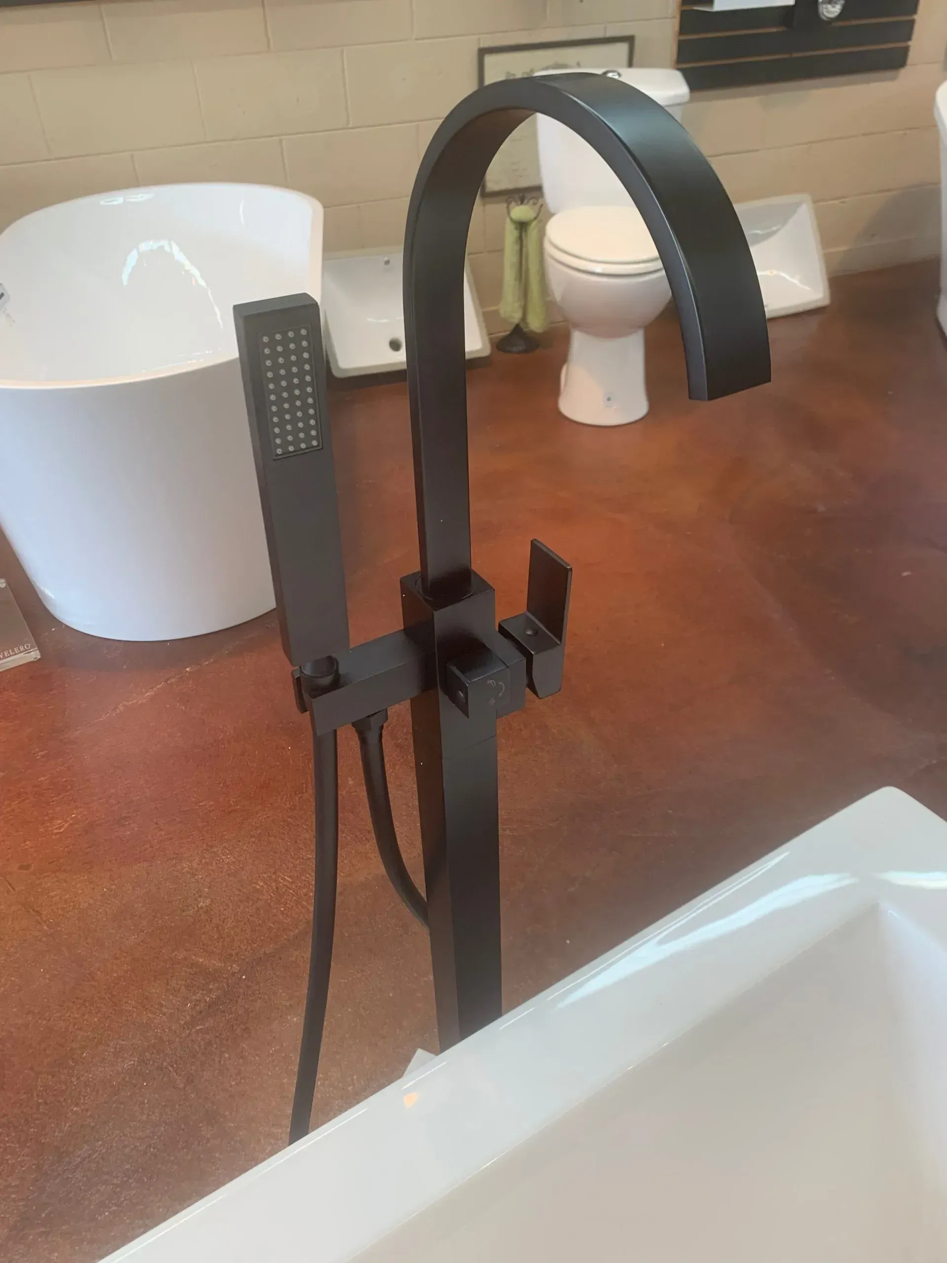 A black bathtub faucet with a hand shower attached to it