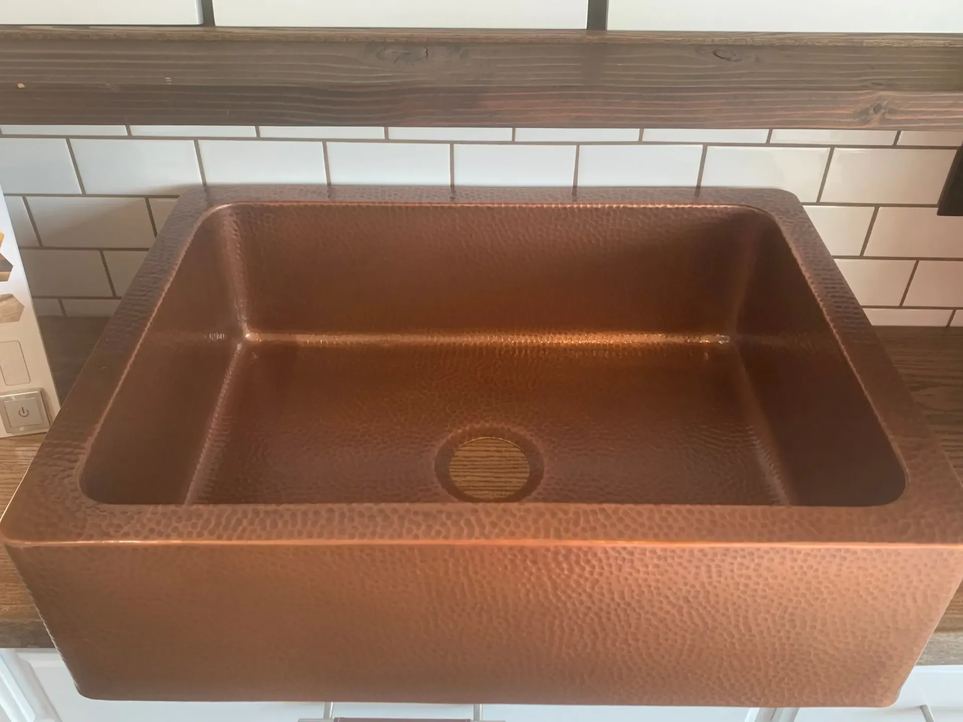 A copper sink is sitting on a counter in a kitchen.