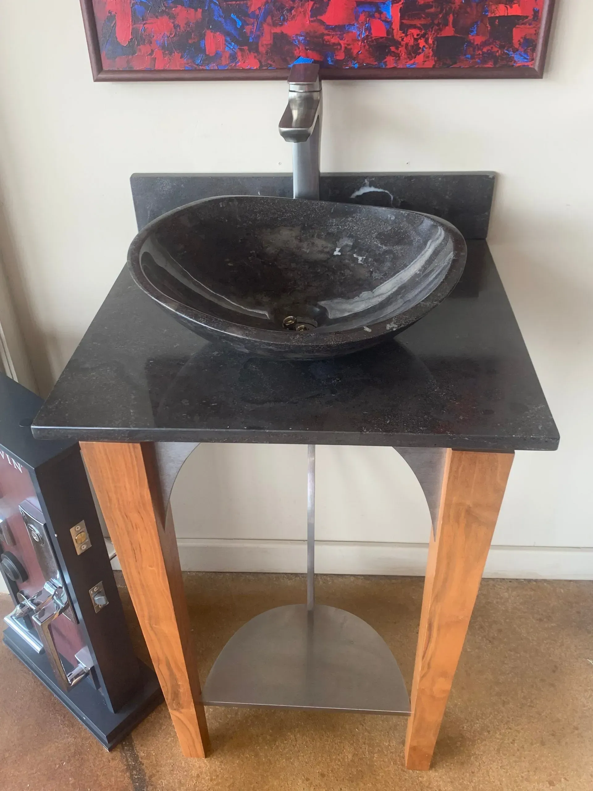 A black sink is sitting on a wooden table