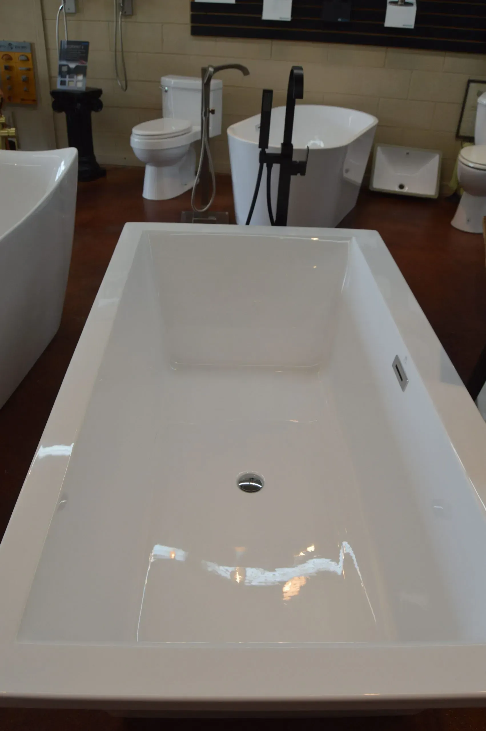 A white bathtub in a bathroom next to a toilet