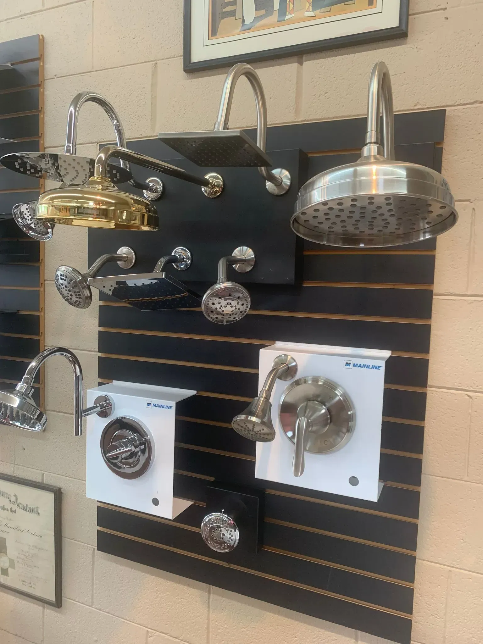 A display of shower heads and faucets on a wall.