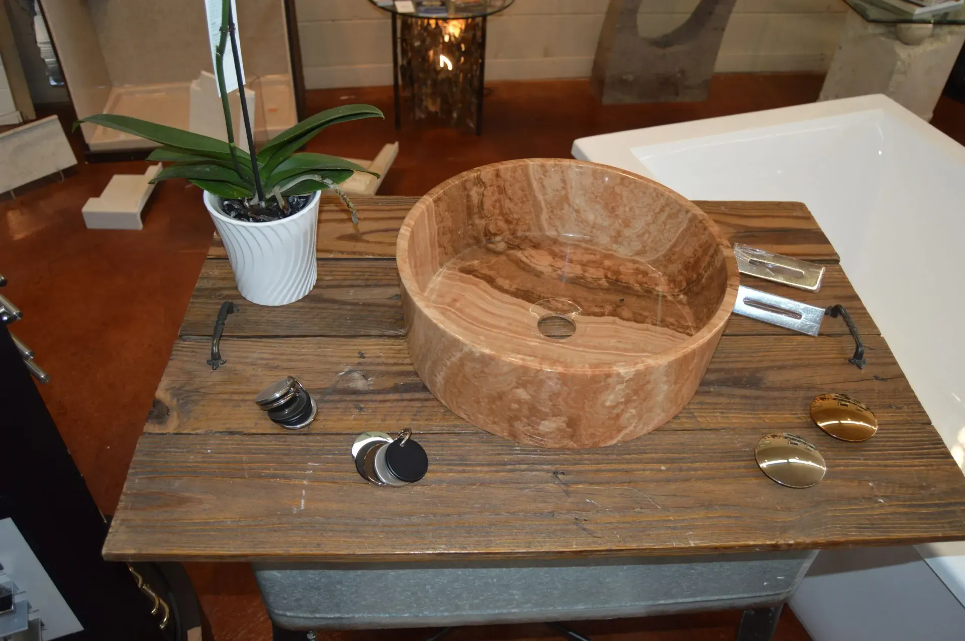 A wooden sink is sitting on a wooden table next to a potted plant.