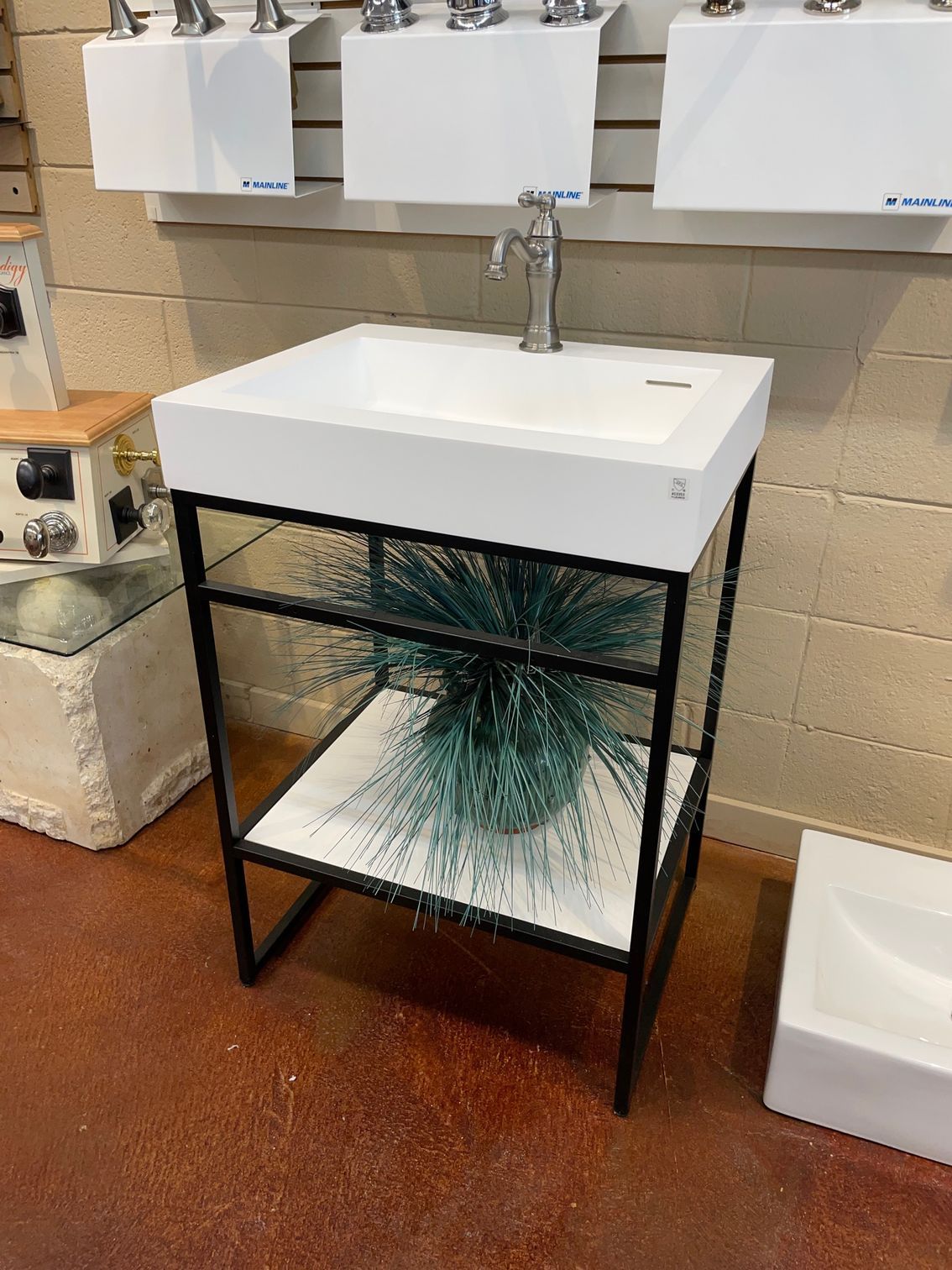 A bathroom sink with a glass shelf underneath it
