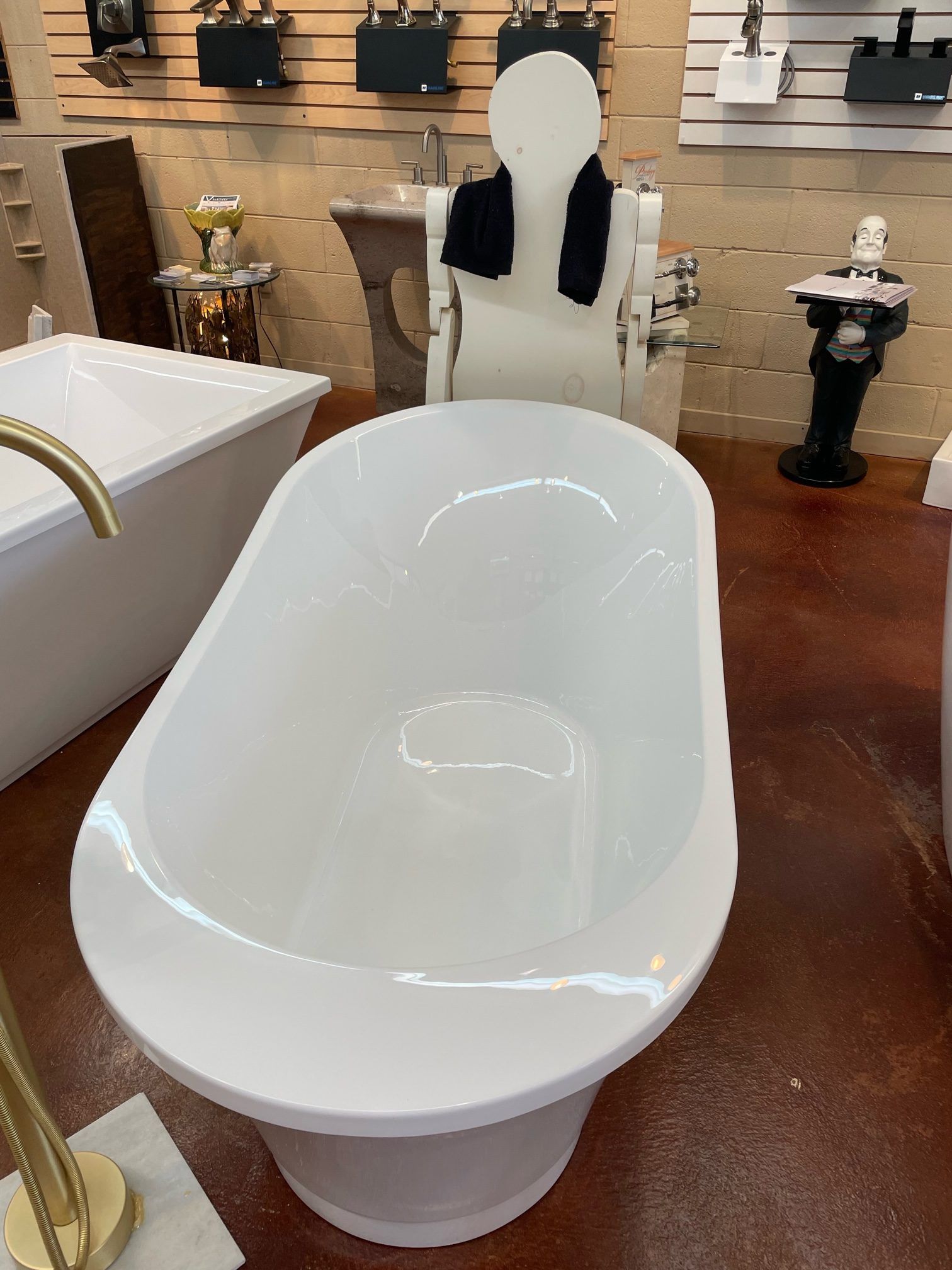 A white bathtub is sitting in a bathroom next to a toilet.