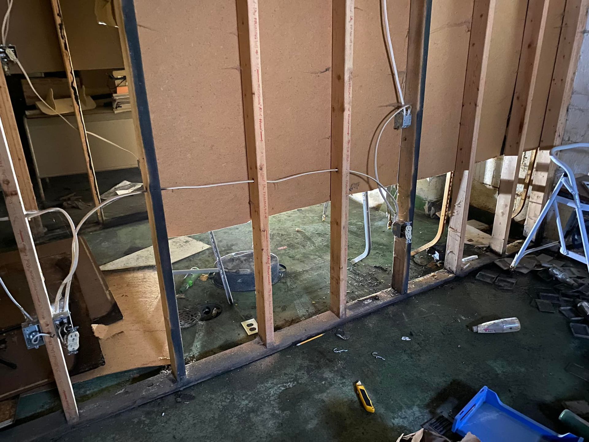 A room with a wooden wall and a lot of wires coming out of it.