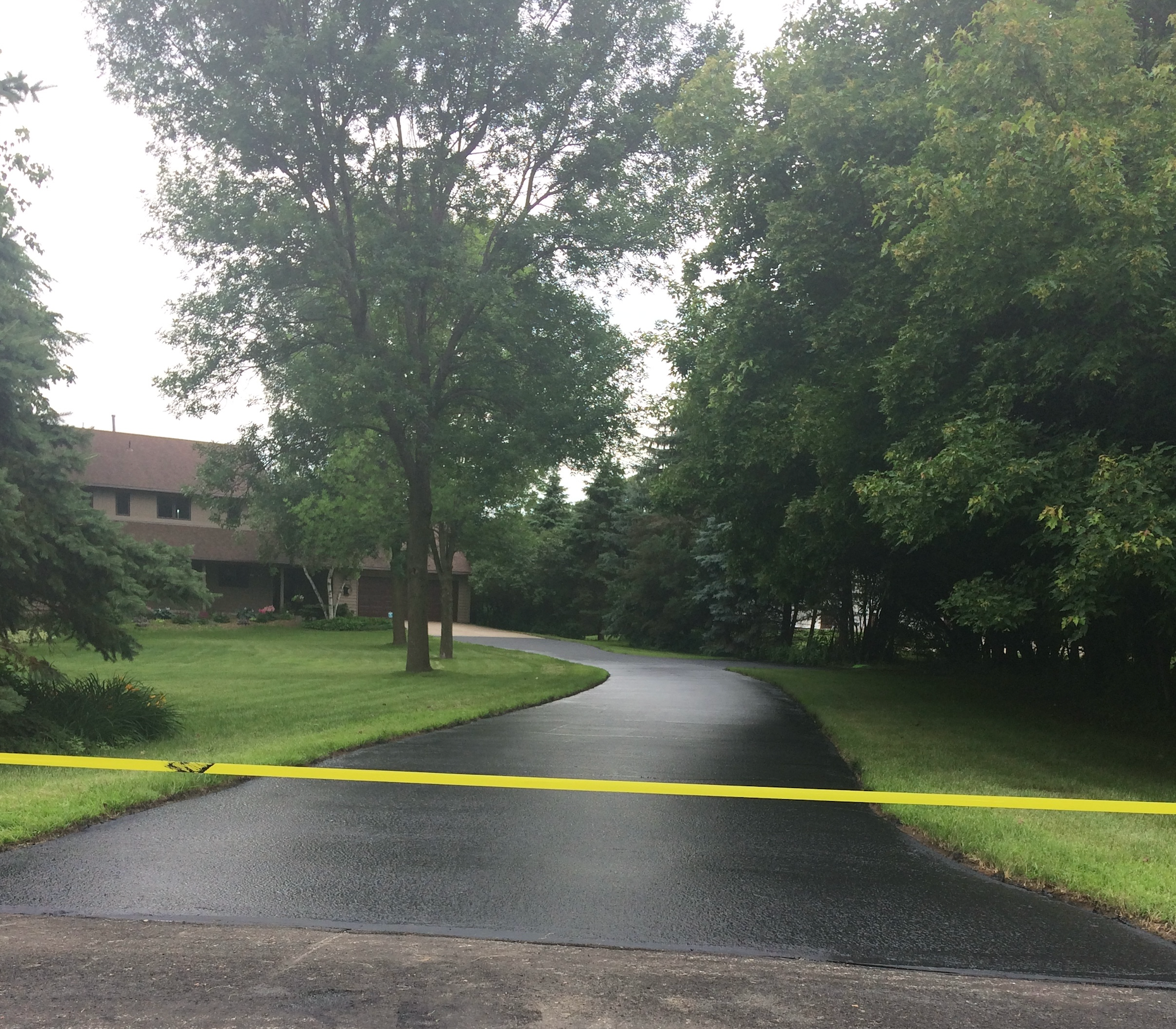 A driveway with a yellow tape along the side of it