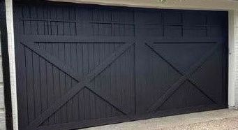 Black garage door with crisscross wooden design.