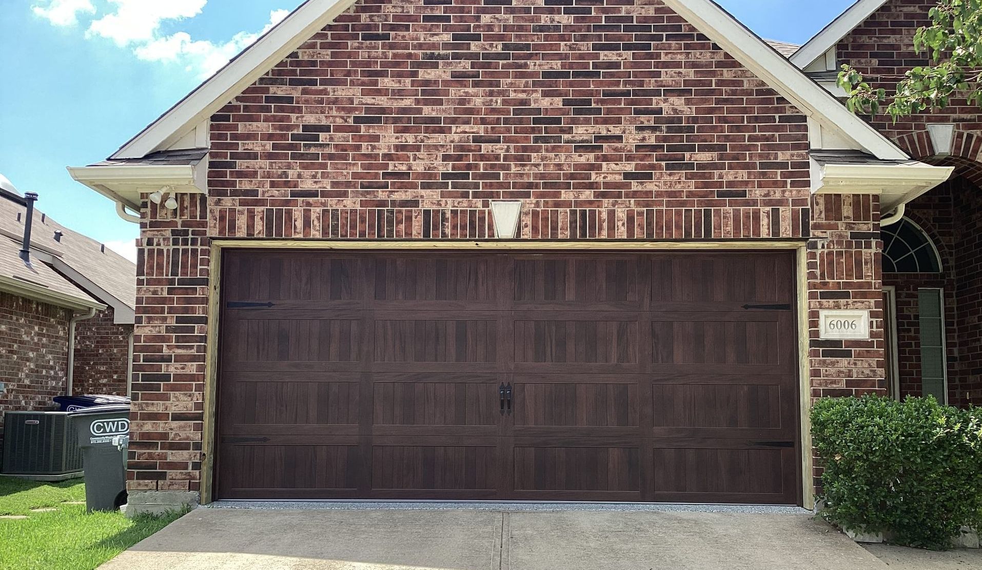 Brown garage door with brick facade.