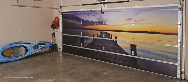 Garage with sunset mural on door, a blue kayak, and a life preserver. Garage with sunset mural on door, a blue kayak, and a life preserver.