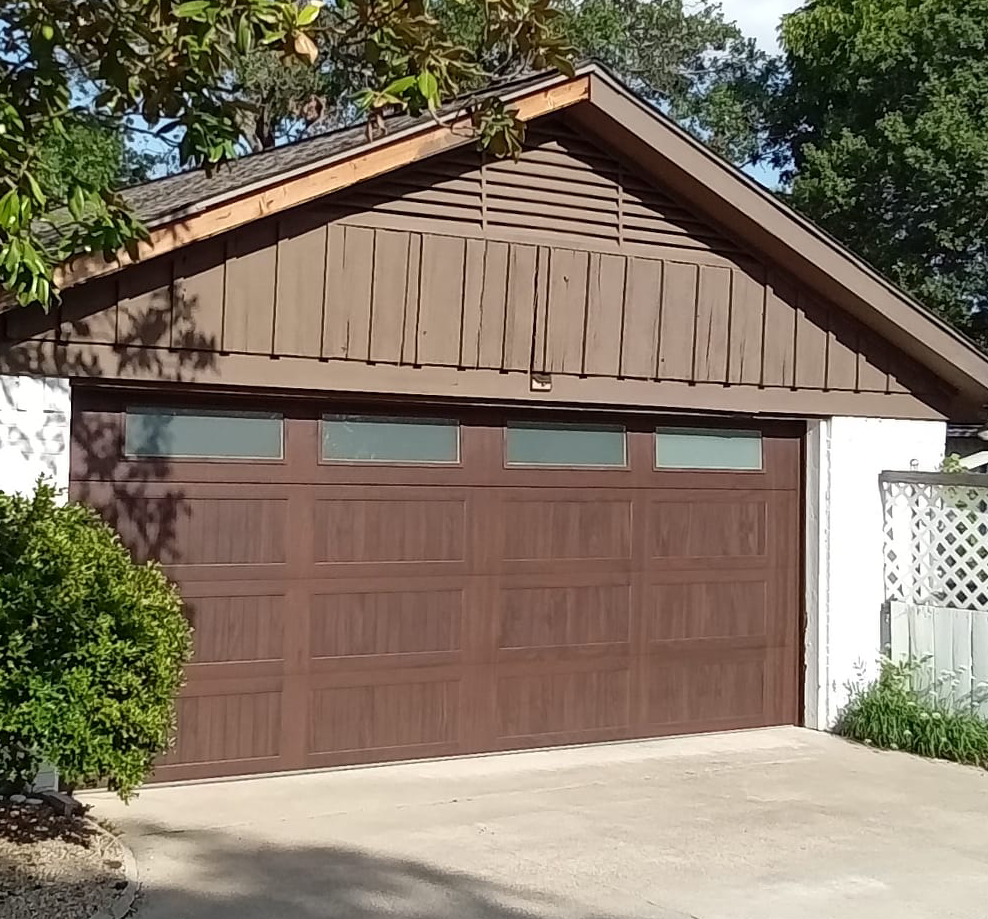 Brown garage door under a brown gable roof.