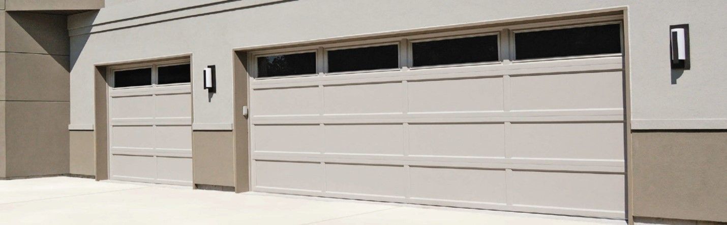 Two tan garage doors with dark window panes and square lights.