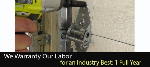 A hand using a power drill on a garage door hinge. Text: We Warranty Our Labor for an Industry Best: 1 Full Year.